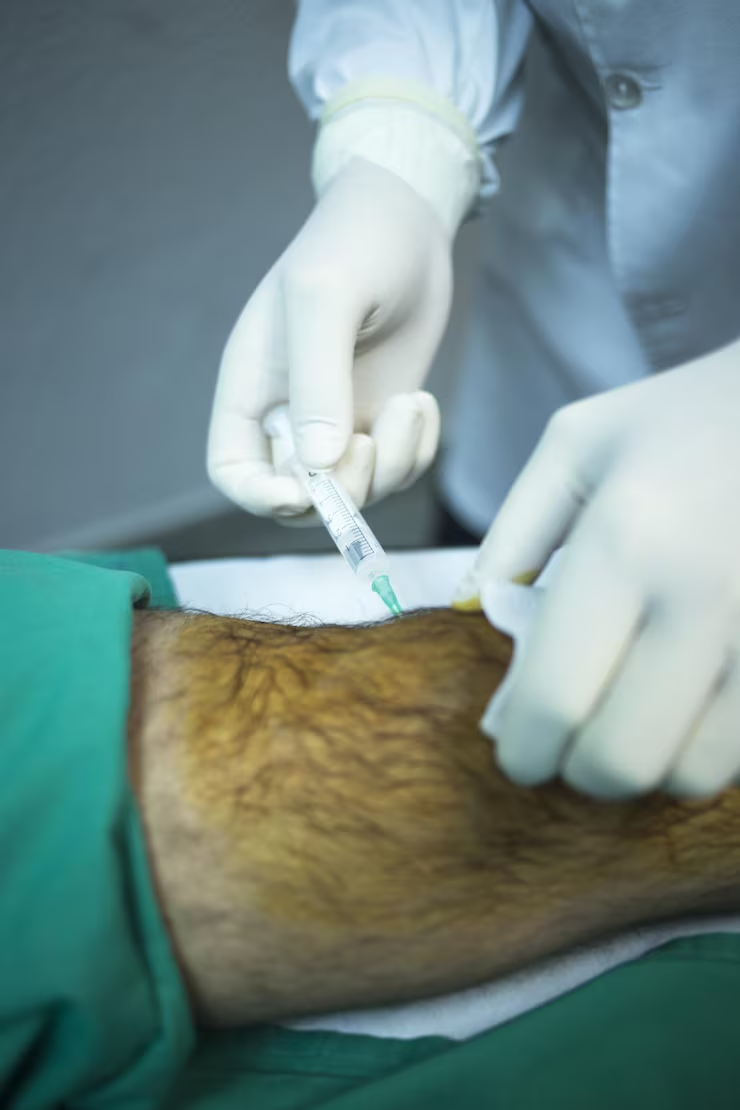 mano-cortada-cirujano-insertando-jeringa-rodilla-paciente_1048944-5603684