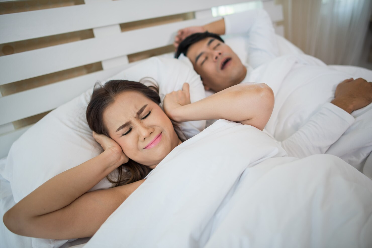 retrato-mujer-bloqueando-orejas-hombre-durmiendo-roncando-cama_1150-4902